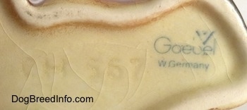 Close up - The underside of a Boxer puppy figurine. On the underside the logo of Goebel W. Germany and next to it is the engraved numbers - CH 567.