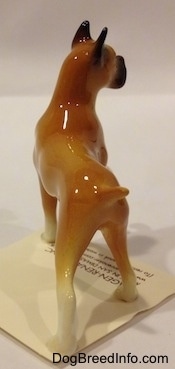 The back of a tan with black and white Boxer mama figurine. The figurine has white paws.