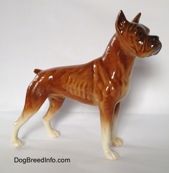 The right side of a brown with black and white Boxer dog figurine. The figurine is very detailed.