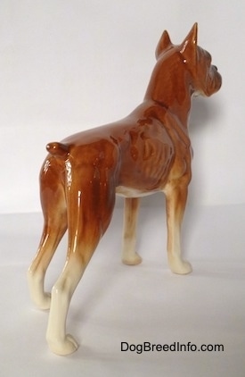 The back right side of a brown Boxer dog figurine. The figurine has a detailed body.