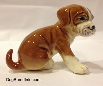 The right side of a brown with white Boxer puppy figurine. The figurine is very glossy.