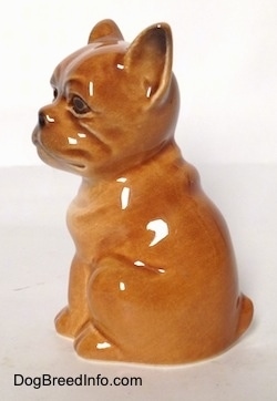The left side of a brown Boxer puppy figurine. The figurine is very glossy.