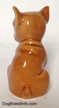 The back side of a brown Boxer puppy figurine. It is hard to tell the difference between the tail and body of the figurine.
