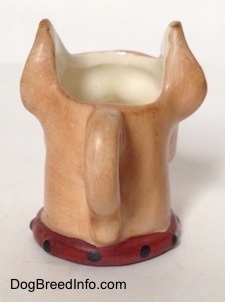 The back of a stein cup that is in the shape of head of a Boxer dog. The handle of the stein looks like it is in the shape of a tail.