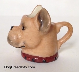 The left side of a stein cup that is in the shape of head of a Boxer dog. The stein has detailed ears.
