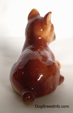 The back of a brown with white and black Boxer puppy figurine. The figurine is very glossy.