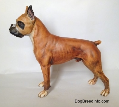 The left side of a brown with black and white Boxer figurine with a matte finish. The figurine is painted accurately.