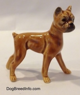 The right side of a brown with black mini Boxer dog porcelain figurine. The figurine has great shaping details.