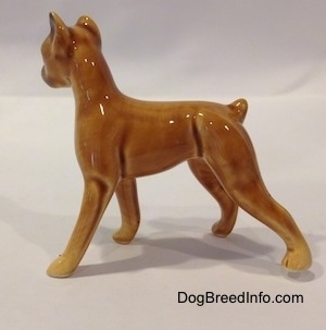 The left side of a brown with black mini Boxer dog porcelain figurine. The figurine has a short tail.