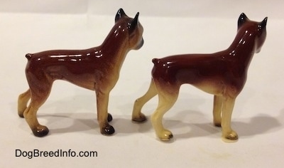 The right side of two different color variations of the miniature Boxer Mama figurine. The figurines both have short tails.