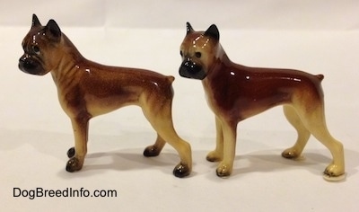 The left side of two different color variations of the miniature Boxer Mama figurine. The figurines are glossy.