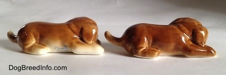 The right side of two brown with white Boxer puppy figurines. The figurines are very glossy.