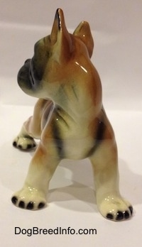 A brown with white and black porcelain Boxer dog figurine.