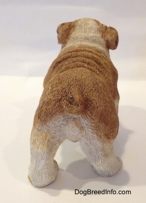 The back side of a brown and white ceramic mold of a Bulldog figurine. It is hard to differentiate the tail of the figurine from the body.