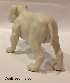 The back left side of a white bisque porcelain Bulldog figurine. The figurine has a smooth body area.