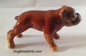 The right side of a brown Bulldog figurine. The ears are easy to differentiate from the head of the figurine.