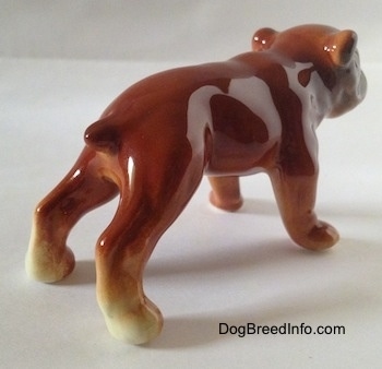 The back right side of a brown Bulldog figurine. The hind paws of the figurine are tan.