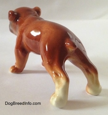 The back left side of a brown Bulldog figurine. The figurine is easily able to differentiate from its body.