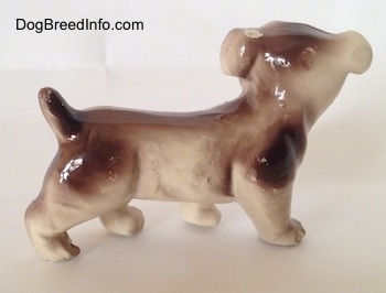 The right side of a brown and white ceramic Bulldog figurine. The figurine is very glossy.