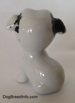 The back of a white with black bone china Bulldog figurine. The figurine is very glossy.