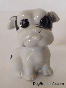 A white with black bone china Bulldog figurine. The figurine has detailed black circles for eyes.