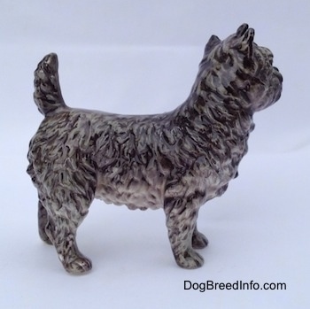 The right side of a gray and white Cairn Terrier figurine. The figurine has fine paw details as the fur coat.