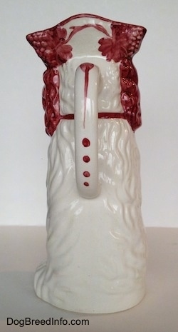 The back of a white and red Cavalier King Charles Spaniel porcelain water pitcher. The pitcher has great hair details.