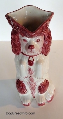 A view of the spout at the top of a white and red Cavalier King Charles Spaniel porcelain water pitcher.