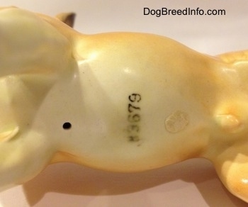Close up - The underside of a porcelain Chihuahua figurine. The figurine has the letter/number combination - H3679 - stamped on it.