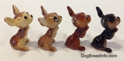 The right side of four variations of a Chihuahua figurines that is in a begging position. The figurines are glossy.