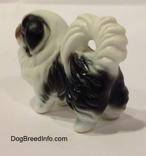 The back left side of a white and black bone china Japanese Chin dog figurine. The figurine has great hair details.
