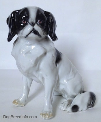 A white with black vintage Goebel double-crown mark Japanese Chin dog figurine. The figurine has great hair details.