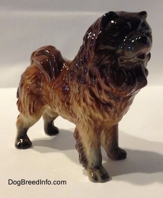 The front right side of a brown with black Chow Chow figurine. The figurine has a black face.