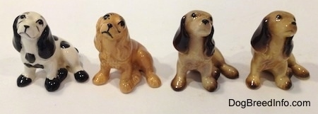 Four color variations of a Cocker Spaniel figurine. The left two figurines have drawn on eyes. The right two figurines have very detailed eyes.
