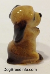 The back right side of a tan with brown ceramic Cocker Spaniel puppy figurine. The figurine lacks fine details.