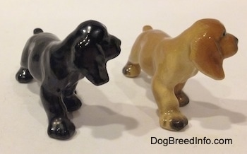 The front right side of two different ceramic Cocker Spaniel puppy figurinee. Both figurines are light on details.