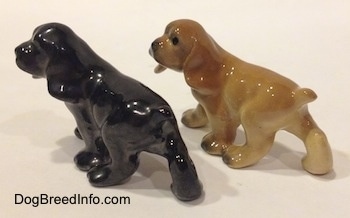 The back left side of two different ceramic Cocker Spaniel puppy figurines.