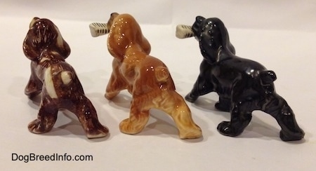 The back left side of three different Cocker Spaniel figurines.
