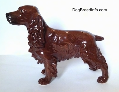 The left side of a shiny brown with black Cocker Spaniel porcelain figurine. It has defined hair.