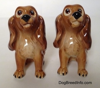 Two brown with tan Cocker Spaniel puppy figurines. The figurines have very detailed eyes and they are designed to look up.
