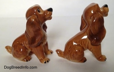The right side of two brown and tan Cocker Spaniel puppy figurines. The figurines has a detailed ears.