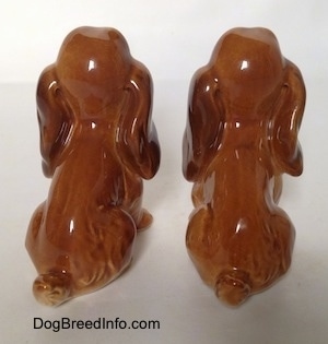 The back side of two brown and tan Cocker Spaniel puppy figurines. The edge of its hair is very detailed.