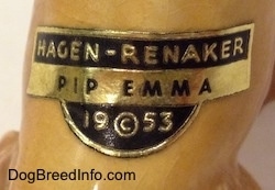 Close up - The tag on the back of a tan ceramic Cocker Spaniel figurine on its back that reads - Hagen-Renaker PIP EMMA 19©53