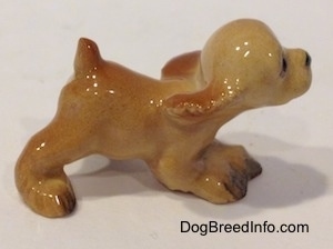 The right side of a tan ceramic Cocker Spaniel puppy running figurine. It has light hair details.