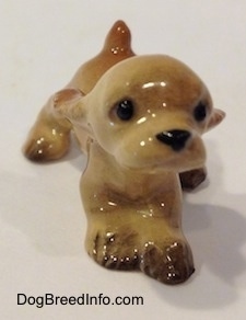 A tan ceramic Cocker Spaniel puppy running figurine. Its front paws are connected.