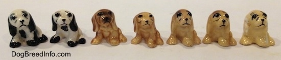 Seven color variations of a Cocker Spaniel figurine. The eyes on the figurines are detailed black circles.
