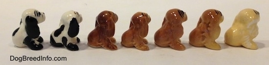 The right side of seven color variations of a Cocker Spaniel figurine. It looks like they are looking up and to the right.