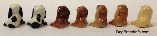The back side of seven color variations of a Cocker Spaniel figurine.