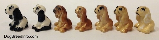 The left side of seven color variations of a Cocker Spaniel figurine. They are very glossy.