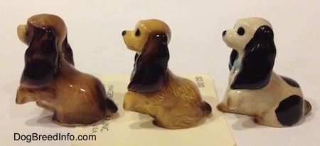 The left side of three different Cocker Spaniel puppy figurines.